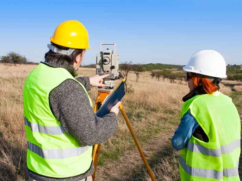 Property Elevation Survey After Heavy Rain Bridgeport West Virginia | Bridgeport Land Surveying Surveyors using a total station to document property elevations and ground conditions in Bridgeport, West Virginia.